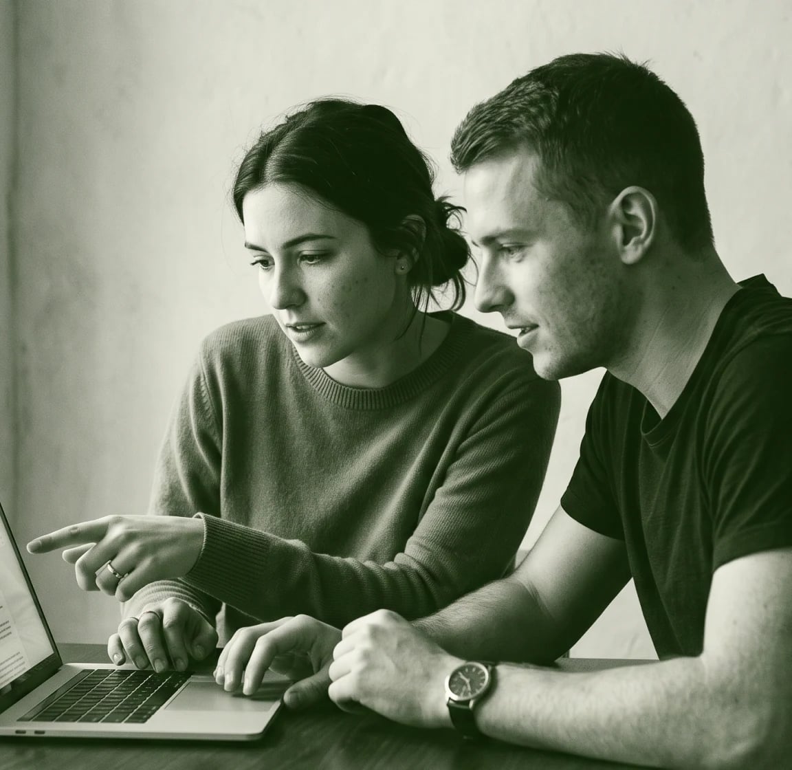 Two people reviewing a laptop together, in green duotone